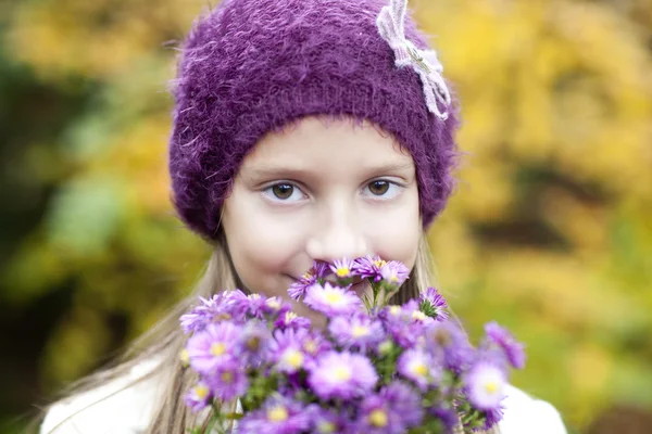 Μικρό κορίτσι με τα λουλούδια το φθινόπωρο του — Φωτογραφία Αρχείου