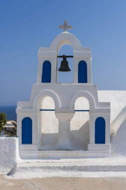 Oia, Santorini, Yunanistan ve Avrupa 'da Güzel Kilise Çanı beyaz ve mavi duvara karşı