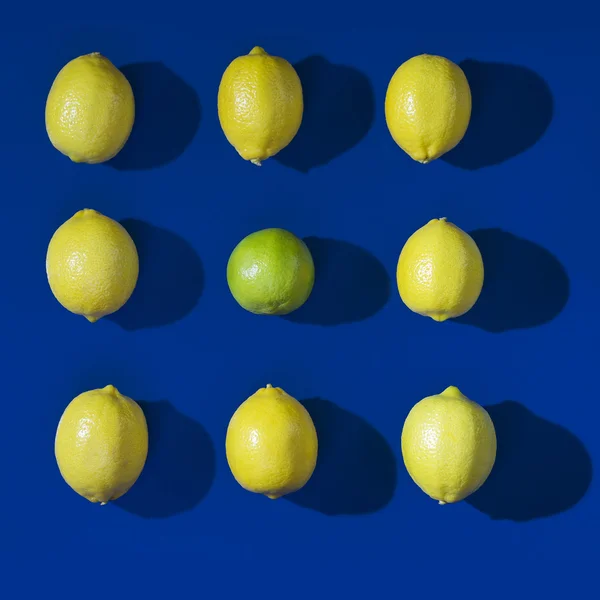 在蓝色背景上的九个柠檬 — 图库照片