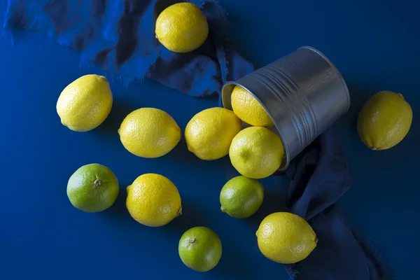Mucchio di limoni su sfondo blu — Foto Stock