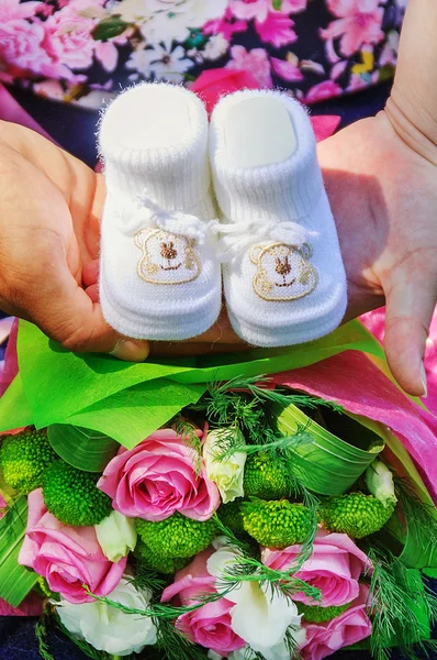 Slofjes in de handen van ouders — Stockfoto