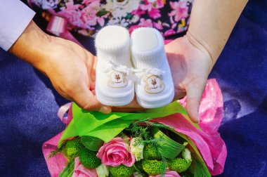 Hamile kadın ve Bebek Patiği tutan baba