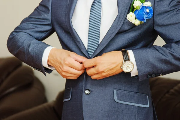 Бизнесмен в синем костюме завязывает галстук — стоковое фото