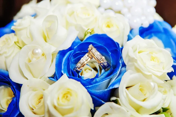 Wedding rings and roses bouquet — Stock Photo, Image