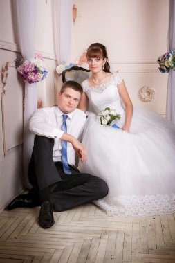 Gelin bir sandalyeye oturur ve damat gelin odasında yerde yakınındaki ile güzel bir iç oturur