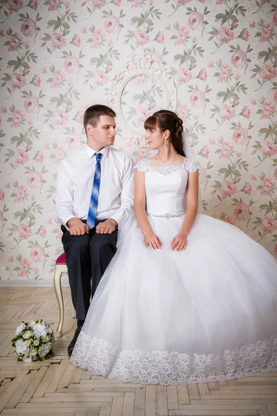 Le marié et la mariée sont assis sur des chaises dans la chambre — Photo