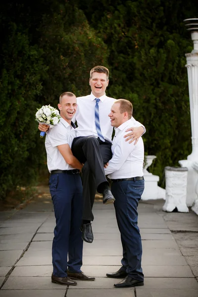 Groomsmen hålla brudgummen på händerna — Stockfoto