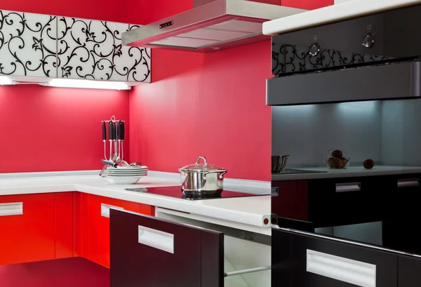 Розкішна нова червона кухня з сучасною технікою з червоним декором — стокове фото