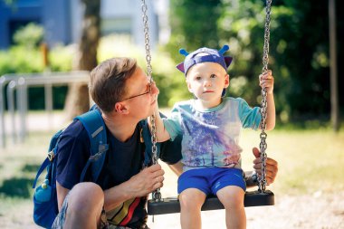 Baba oğul (4-5) parkta salıncakta