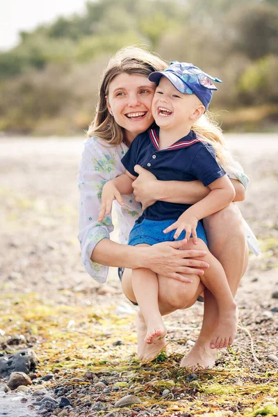 幸せの母と息子がビーチで荒れ狂う — ストック写真