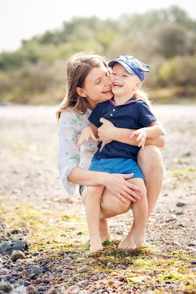 幸せの母と息子がビーチで荒れ狂う — ストック写真