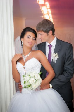 Damat ve gelin düğün buket ile beyaz bir sütun stand