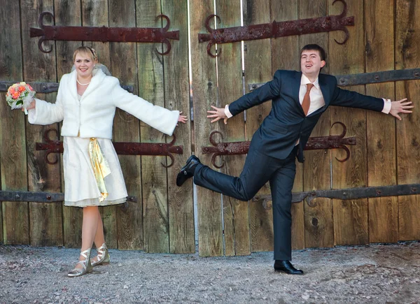 Novio y la novia de pie cerca de la puerta de madera —  Fotos de Stock