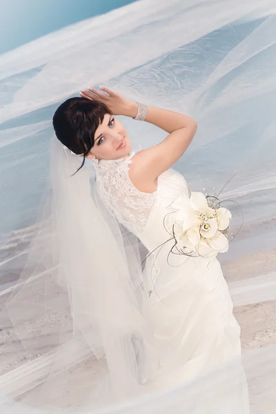 Bella sposa in piedi vicino alla spiaggia — Foto Stock