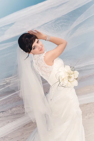 Bella sposa in piedi vicino alla spiaggia — Foto Stock