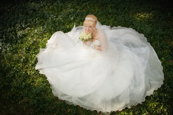 Nevěsta se nachází na zelené trávě — Stock fotografie