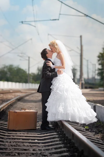 新郎和新娘，行李箱在火车站 — 图库照片