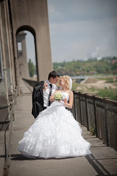 Прекрасная невеста и жених возле моста — стоковое фото