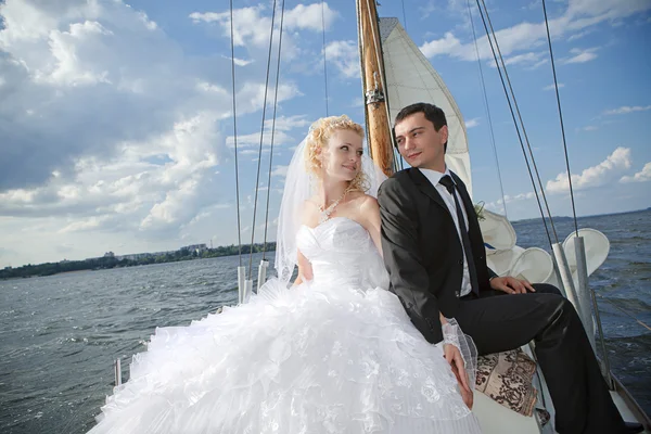 Lyckliga bruden och brudgummen kramas på en yacht — Stockfoto