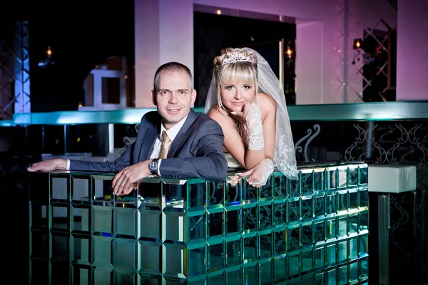Beautiful young bride and groom next to bar — Stock Photo, Image