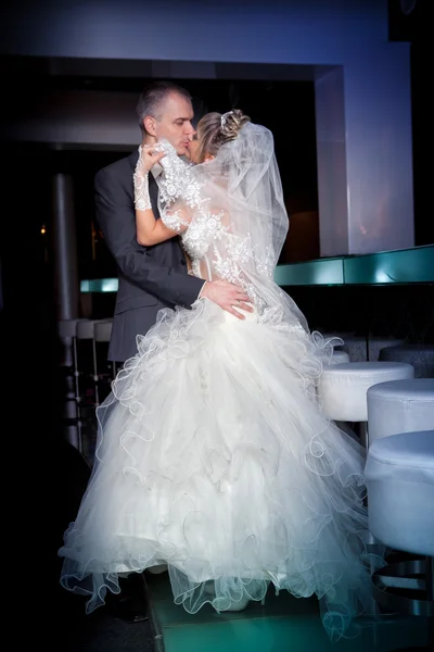 Beautiful young bride and groom next to bar — Stock Photo, Image