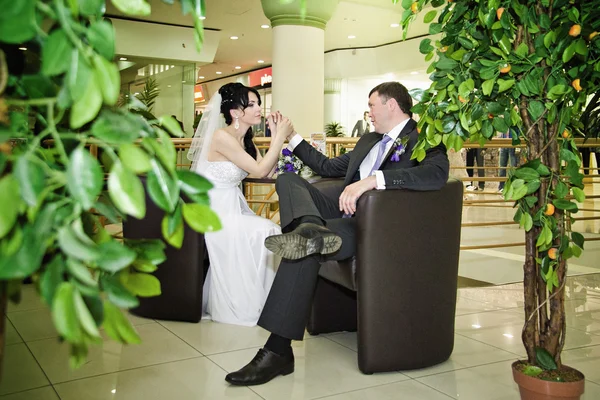 Marié et la mariée avec un bouquet de roses dans le café — Photo