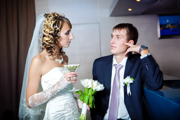 Bruid en bruidegom drinken champagne in bar — Stockfoto