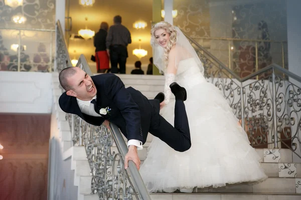 Счастливая невеста и жених играют дурака на лестнице — стоковое фото