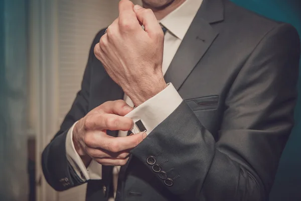 Groom clasps cuff links on a shirt sleeve close up — Stock Photo, Image