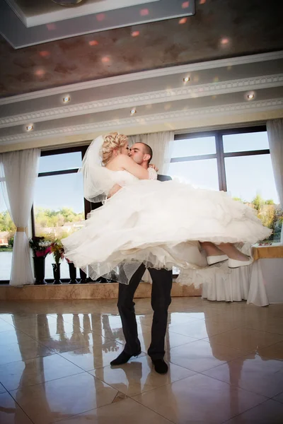 Kiss and dance young bride and groom in banqueting hall — Stock Photo, Image