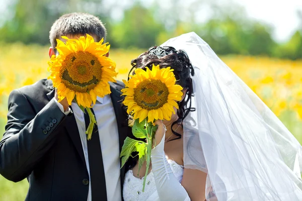 Ženich s nevěstou uzavírá slunečnic, na kterých je zastoupena smajlíka — Stock fotografie