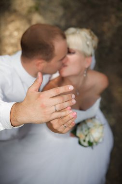 Gelin ve Damat Düğün halkalar ve arka planda öpüşme ile eller ortaya