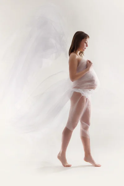 Young pregnant woman with blowing white material — Stock Photo, Image