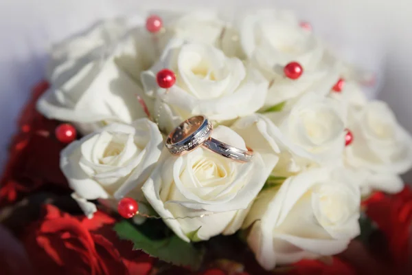 Anéis de casamento de ouro em um buquê de rosas bege — Fotografia de Stock