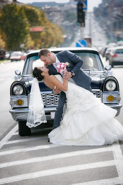 Gelin ve damat sokakta retro araba yakın: — Stok fotoğraf