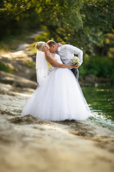 Glad gift par stående på stranden — Stockfoto