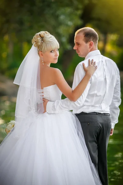 Brudgummen och bruden på promenad i deras bröllopsdag — Stockfoto