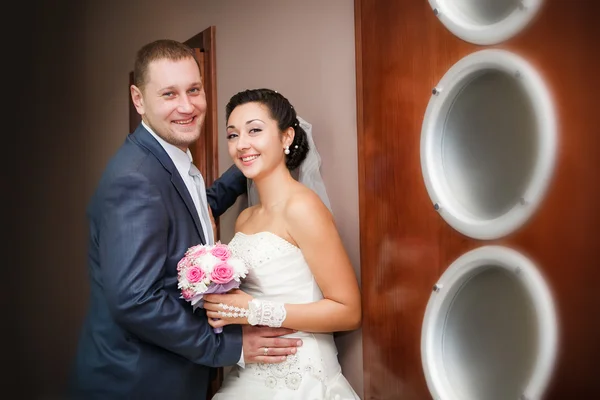 Счастливая невеста и жених на свадебной прогулке в современном зале отеля — стоковое фото