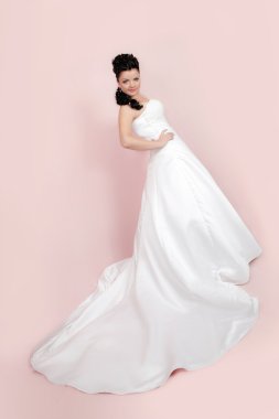 Stüdyo portre pembe bir arka plan üzerinde mutlu bir gelin