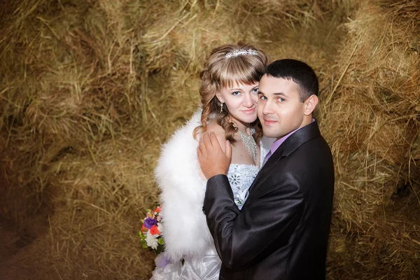 Closeup portrait of bride and groom hugging on hay at stable — Stock Photo, Image