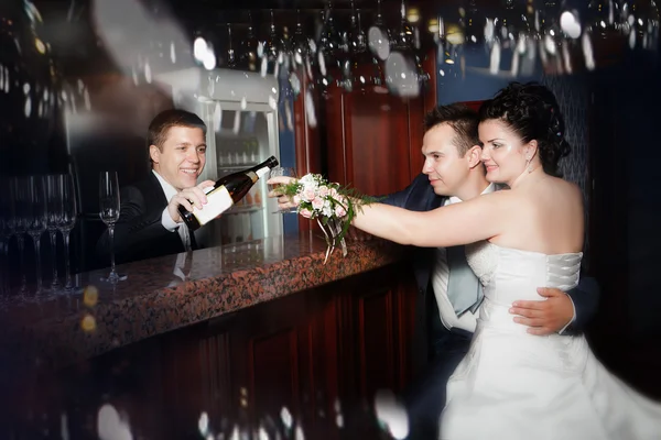 Cheerful bartender pouring cocktails for groom and bride — Stock Photo, Image