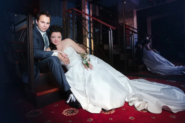 Novia feliz y novio en el paseo de la boda en el moderno hall del hotel — Foto de Stock