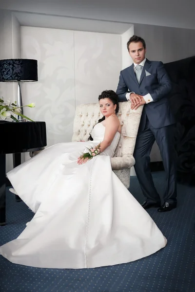 Bride sitting and Groom stand on a chair — Stock Photo, Image