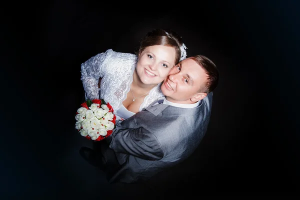 Groom et la mariée avec un bouquet de mariage de roses dans une main levez les yeux — Photo