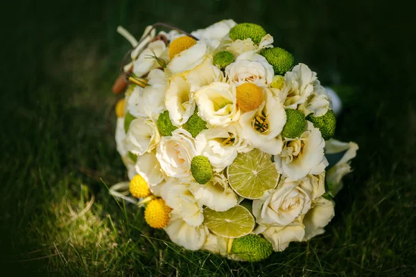 Bröllop bukett från beige rosor, kanel, citron, en kalk på ett grönt gräs — Stockfoto