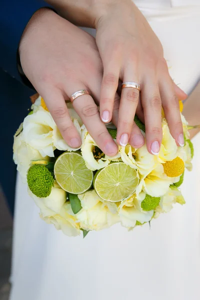 Bouquet de mariage entre les mains de la mariée et du marié — Photo