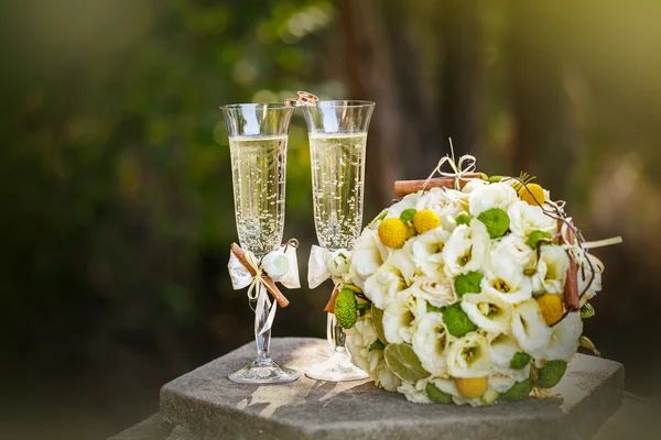 Wedding rings with roses and glasses of champagne — Stock Photo, Image