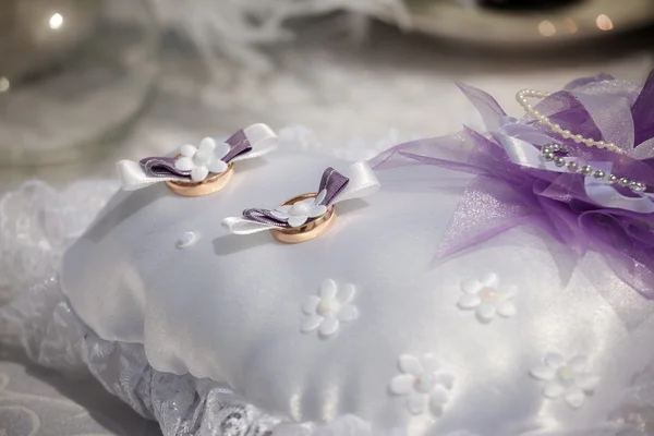 Anillos de boda se encuentran en una almohada pequeña —  Fotos de Stock