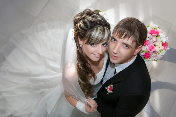 Groom et la mariée avec un bouquet de mariage de roses dans une main levez les yeux — Photo