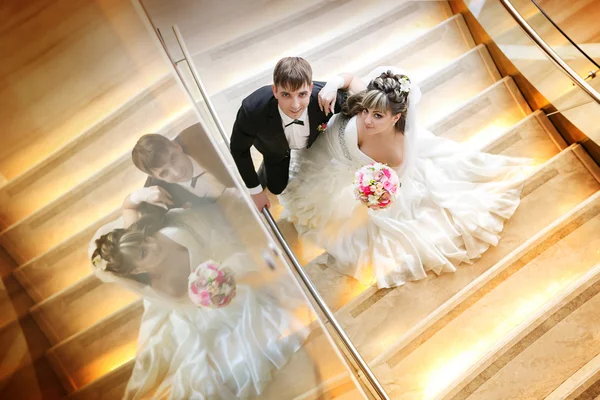 Happy bride and groom on stair at hotel — Stock Photo, Image